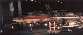 Des techniciens au travail sur un X-Wing